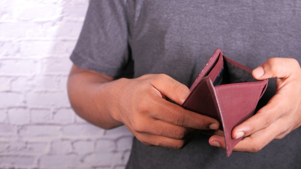 a man showing his empty wallet indicating poor credit