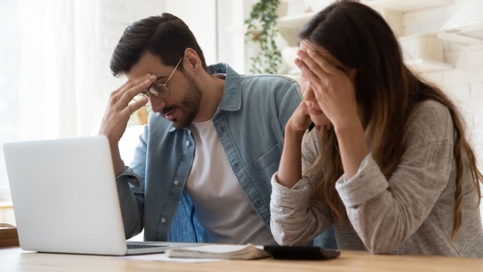 Young family couple feeling disappointed by high utility bills